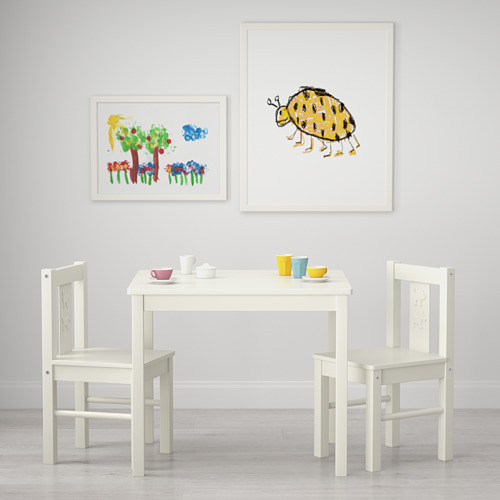Configuración de mesa para niños con sillas, tazas y láminas artísticas. Adecuado para manualidades y juegos.