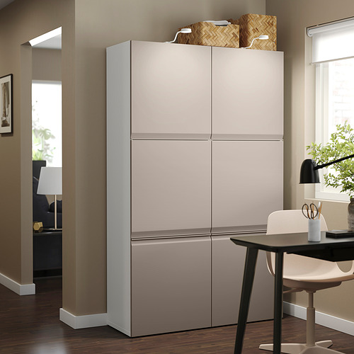 Gran mueble de almacenaje gris BESTÅ con dos puertas junto a la mesa de comedor, con un diseño elegante y moderno para la organización del hogar.