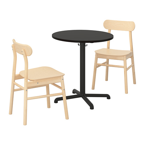 Un juego de comedor STENSELE con una mesa redonda negra y dos sillas de madera clara. Las sillas tienen respaldos y asientos curvos para mayor comodidad.