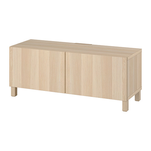 Un mueble de tv de madera ligera llamado BESTÅ. Cuenta con dos compartimentos cerrados con un diseño elegante y minimalista y estantes ajustables para un almacenamiento flexible.