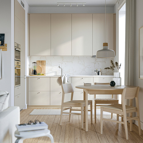 Cocina moderna con gabinetes ligeros, mesa de madera y placa para salpicaduras de mármol.