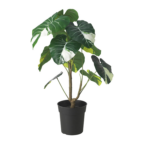 Planta artificial en maceta llamada FEJKA con grandes hojas verdes y blancas, hecha de materiales reciclados y diseñada para parecerse a una planta de interior tropical.