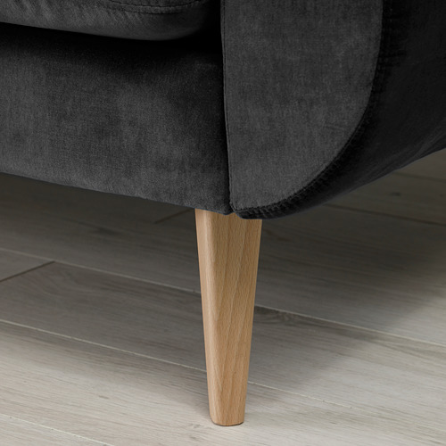 Primer plano de la pata del sofá gris moderno, elegante acabado en madera, diseño elegante.