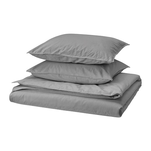 Un conjunto de ropa de cama gris doblada que incluye una funda nórdica y dos fundas de almohada, hechas 100% algodón.