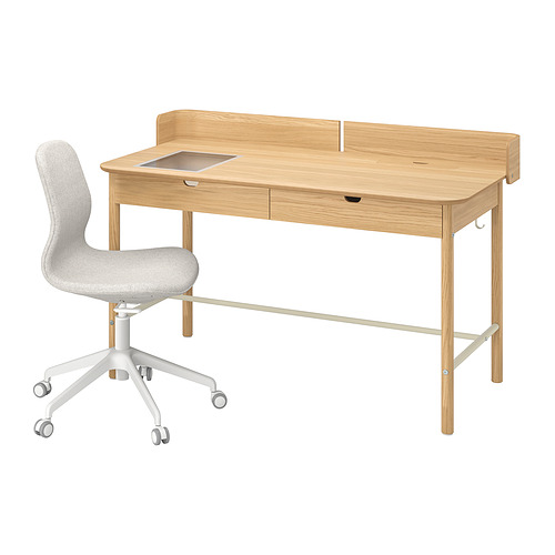 Un escritorio de madera de color madera clara con una silla gris, con un cajón y un sistema de gestión de cables.