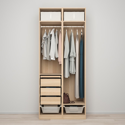 Un armario minimalista con camisas y tops, con cuatro cajones y dos cestas de alambre en la parte inferior para almacenamiento adicional.