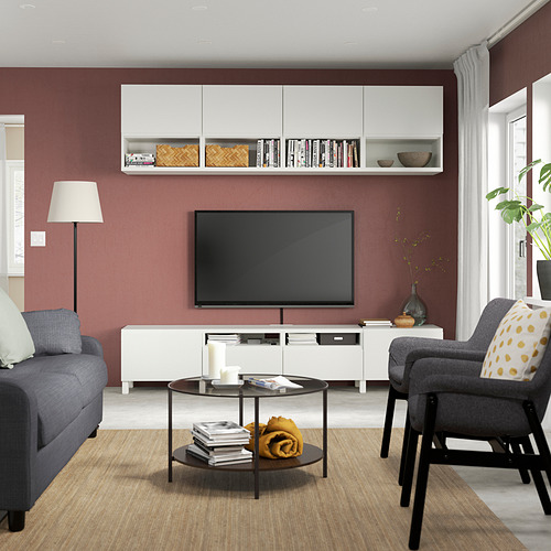Sala de estar moderna con paredes rojas, sofá gris, mueble de TV y decoración.