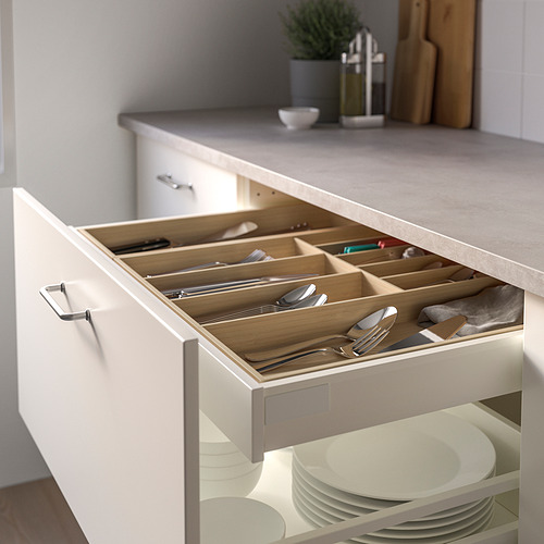 Cajón de utensilios de cocina con bandeja de bambú que contiene tenedores, cucharas, cuchillos y herramientas.