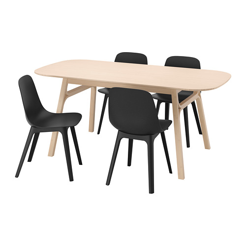Un juego de comedor voxlov con una mesa de madera marrón claro y cuatro sillas negras, diseñado para un fácil montaje y comodidad.