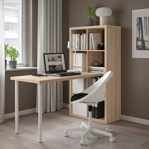 Moderna configuración de oficina en casa con escritorio y almacenamiento KALLAX de madera clara. Silla de oficina blanca, portátil y decoración. Diseño limpio y organizado.