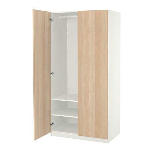 Un armario PAX de IKEA con puertas de madera clara, interior blanco, estantes ajustables y bisagras de cierre suave.