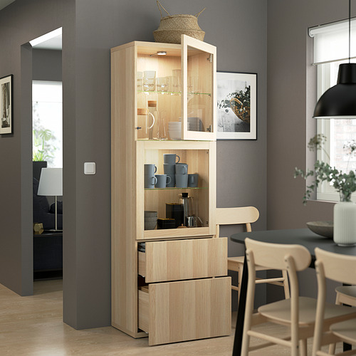Mueble de madera con puertas de cristal que muestran tazas y platos, estantes y cajones ajustables, junto a la mesa de comedor.