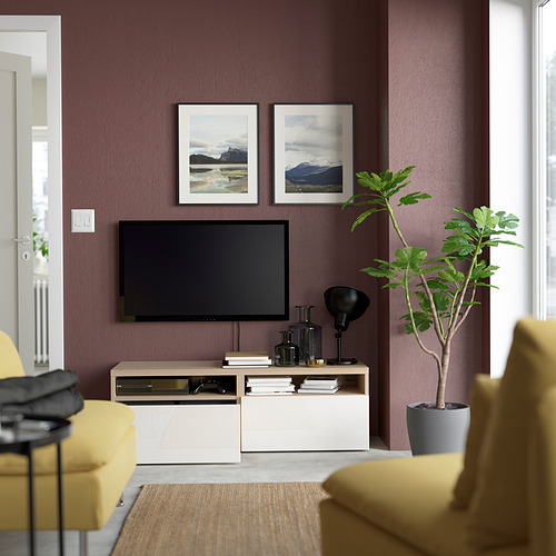 Sala de estar moderna con mueble de televisión BESTÅ, sillas amarillas y plantas.