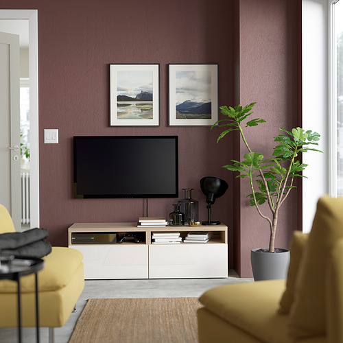Sala de estar moderna con paredes granates, mueble de tv BESTÅ, sillas amarillas, planta verde.