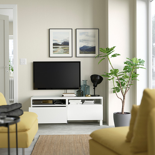 Sala de estar moderna con mueble de TV BESTÅ, arte, sofá amarillo y planta.