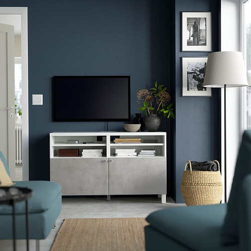 Sala de estar moderna con banco de tv BESTÅ, sofá azul, cesta de mimbre.