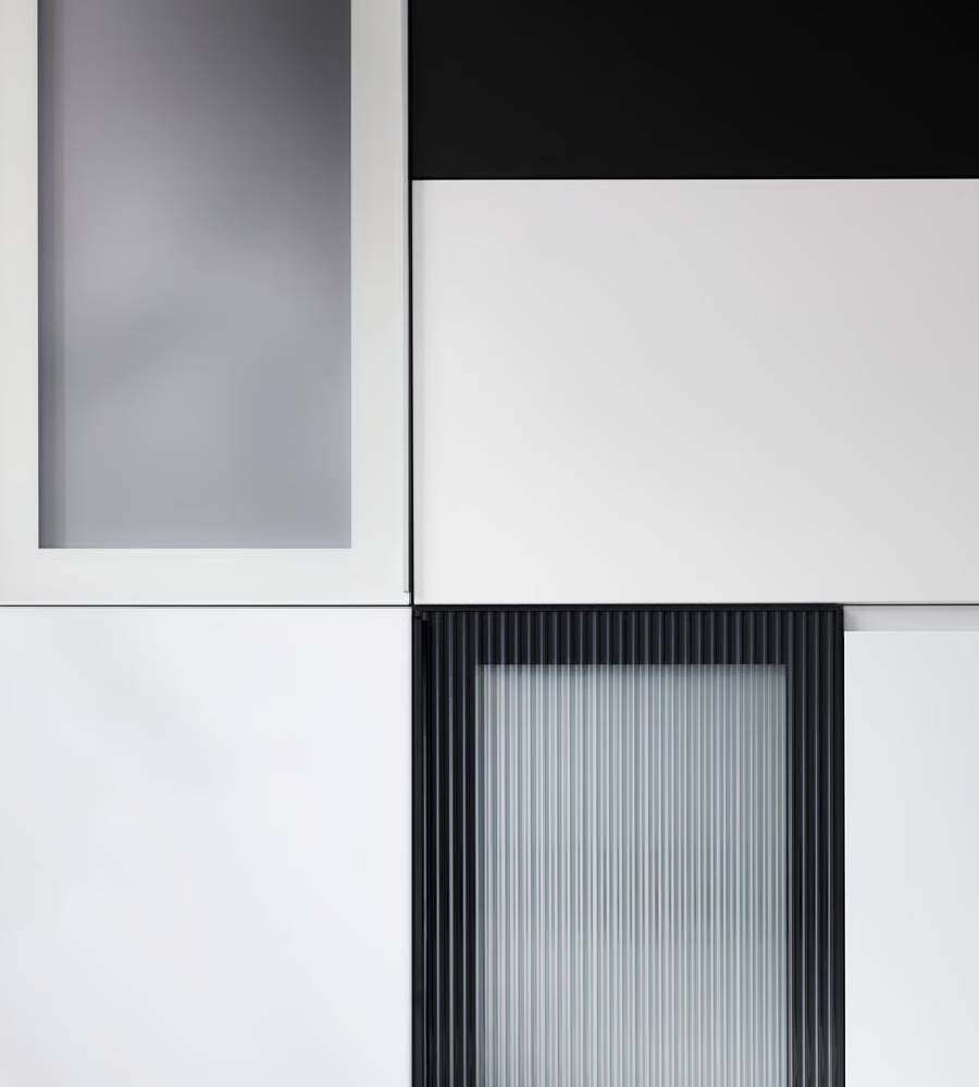 Dierently-coloured kitchen fronts with modern expressions are placed in a graphic pattern against a dark background.