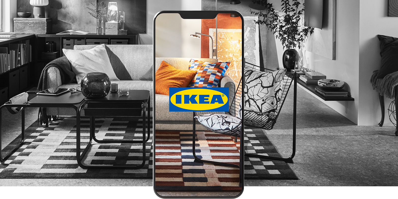 Smartphone showing the colorful IKEA logo over a black and white modern living room.
