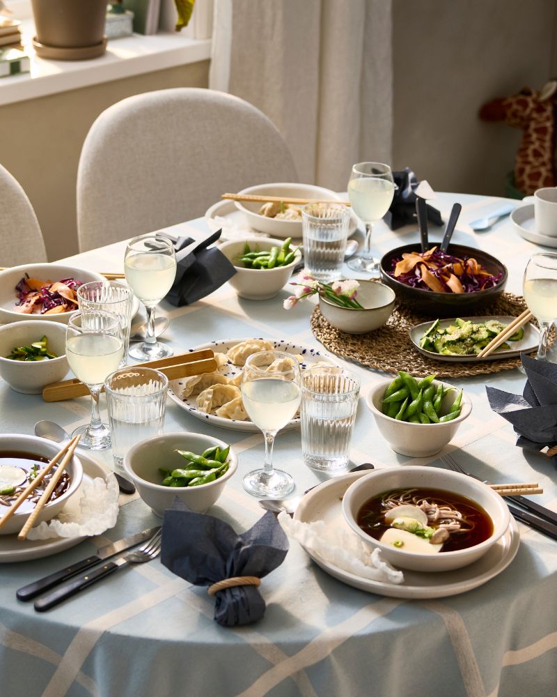 A ROSENTORP extendable table has been set for a festive meal with soup served in bowls and dumplings on a serving plate.