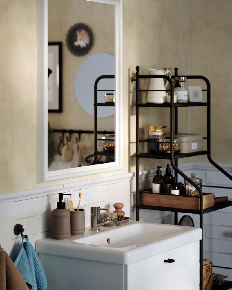 A PINGSTSYREN mirror with a white-painted, solid pine frame hangs above a white wash-stand in a traditionalstyled bathroom.