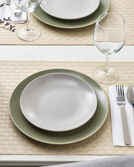A FÄRGKLAR and MOSSMAL side plates next to a wine glass on a table