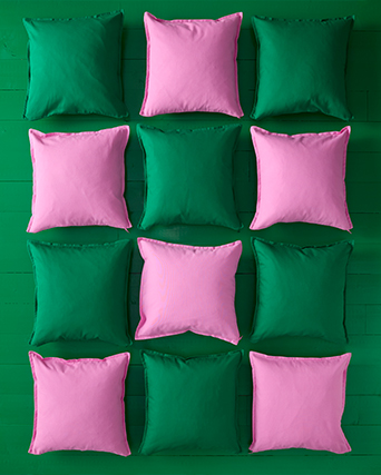IKEA decorative cushions in green and pink tones on a green background. Adding color and texture simply to your space.
