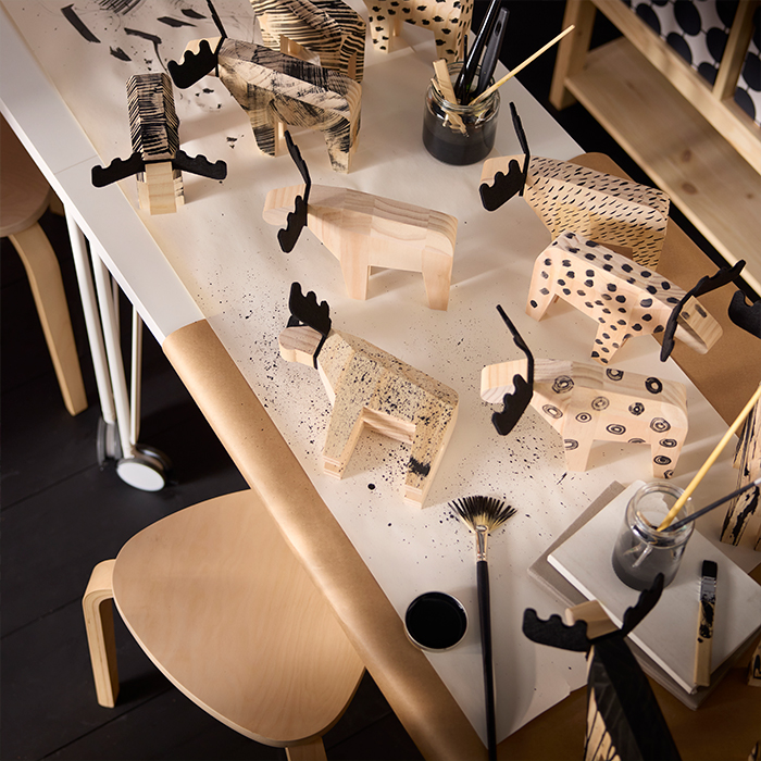 IKEA craft table with wooden moose figures and painting supplies. Ideas for creative projects at home.