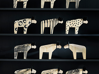 IKEA decor with wooden moose figures on dark shelves. Unique accessories to personalize your home.