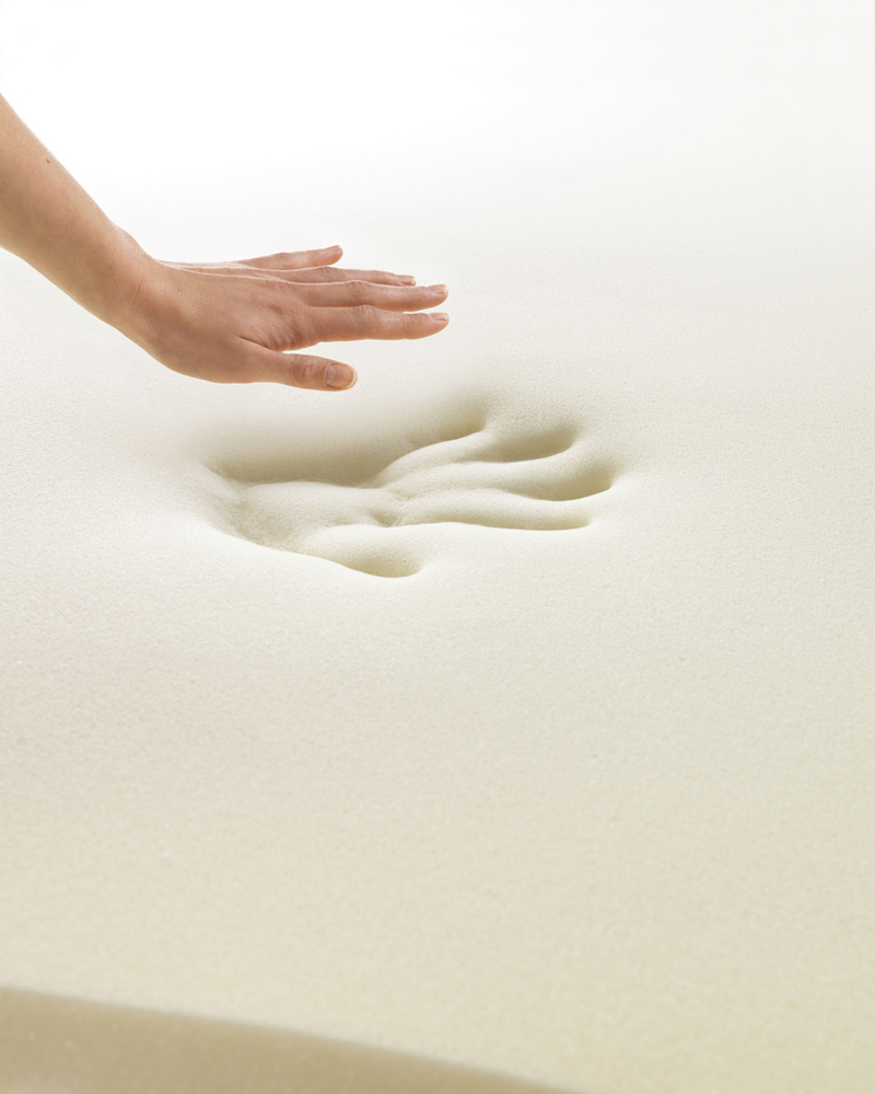 A hand that has been pressed into memory foam and lifted out, showing the imprint that it has left behind in the memory foam.