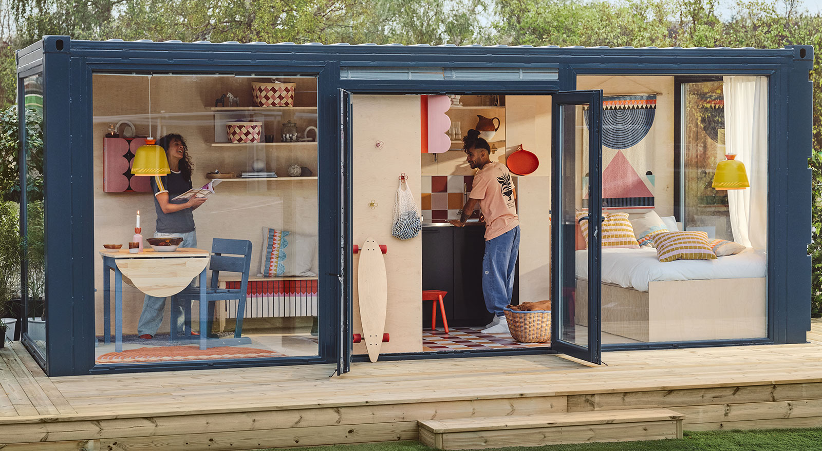 Apartment made from shipping containers, with windows to the bedroom and living room; open door shows IKEA OMMJÄNGE items.