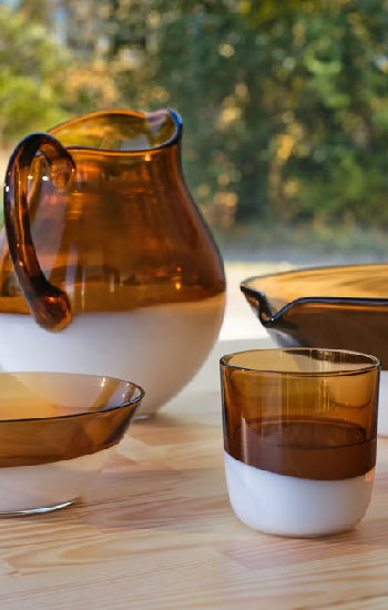 Dark glass tableware set with bowl, pitcher, and cups.