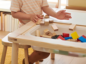 un niño metiendo juguetes en su mesa infantil