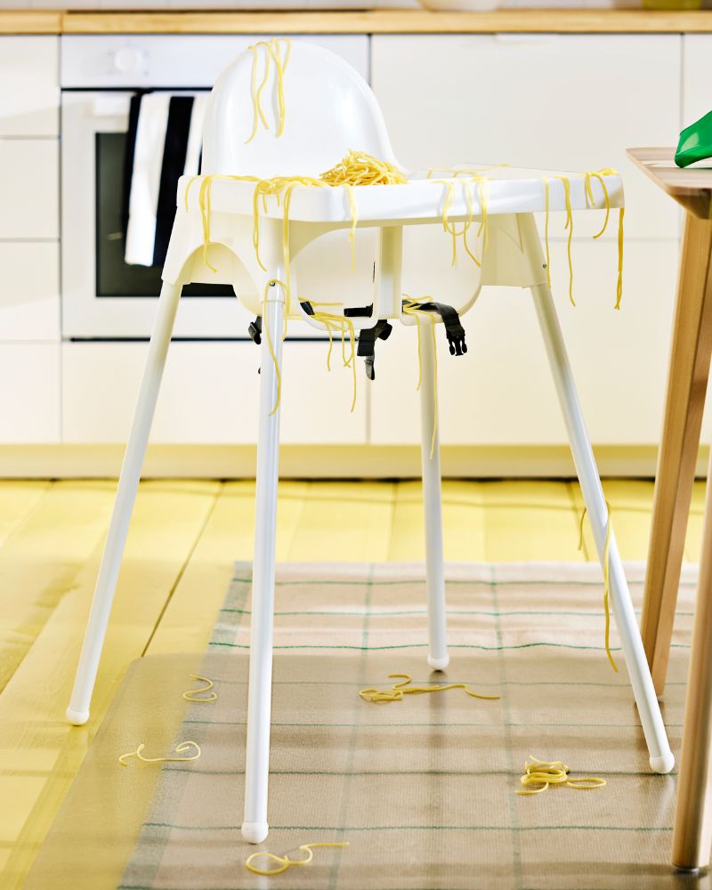 White baby ANTILOP highchair with safety  straps in modern kitchen setting.