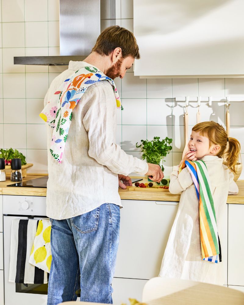 Father and daughter prepping a meal  with bright linen RINNIG tea towels in a  Scandinavian modern kitchen.