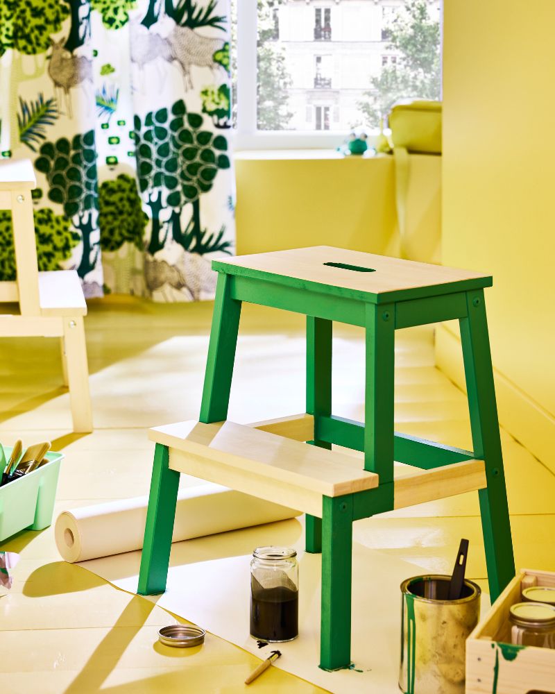Wooden BEKVÄM step stool painted to look  like a green frog in a modern kitchen.