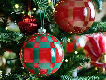 VINTERFINT tree ornaments with a bold checkered pattern adorn the branches of a festive Christmas tree.