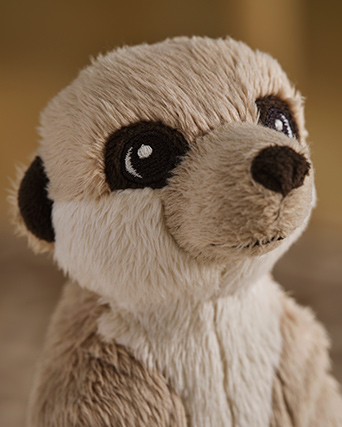 A beige SANDLÖPARE soft toy meerkat with large eyes sits upright, showcasing its soft fur and endearing expression.