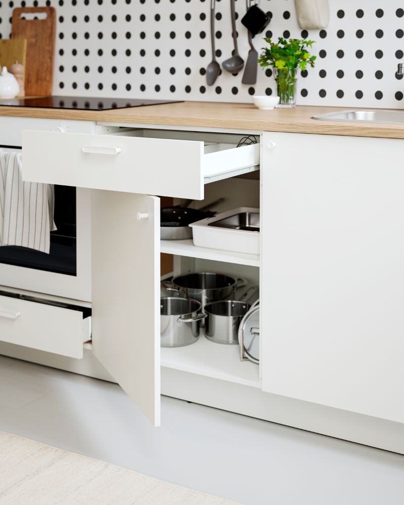 KNOXHULT low cabinet with doors and drawer, inside it has pots and pans.