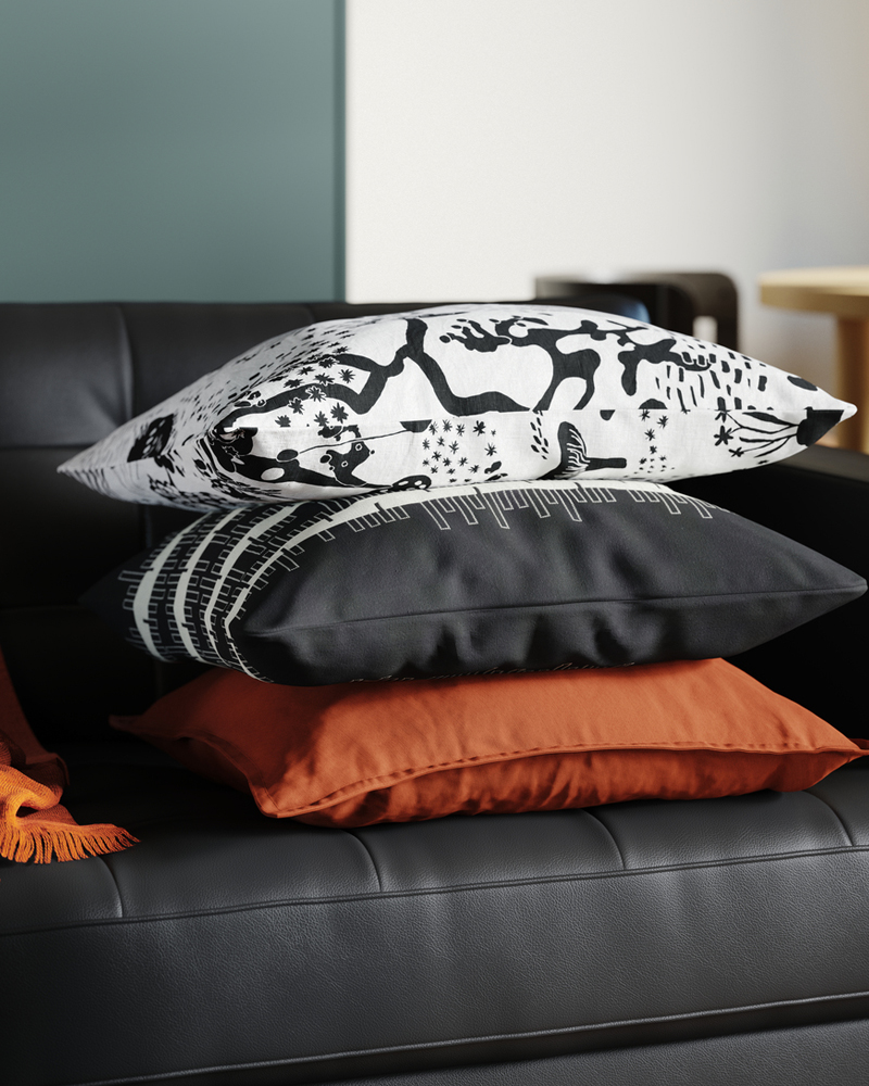 Three cushions lie on top of a leather and coated fabric 3-seat sofa in an Instagram worthy living room.