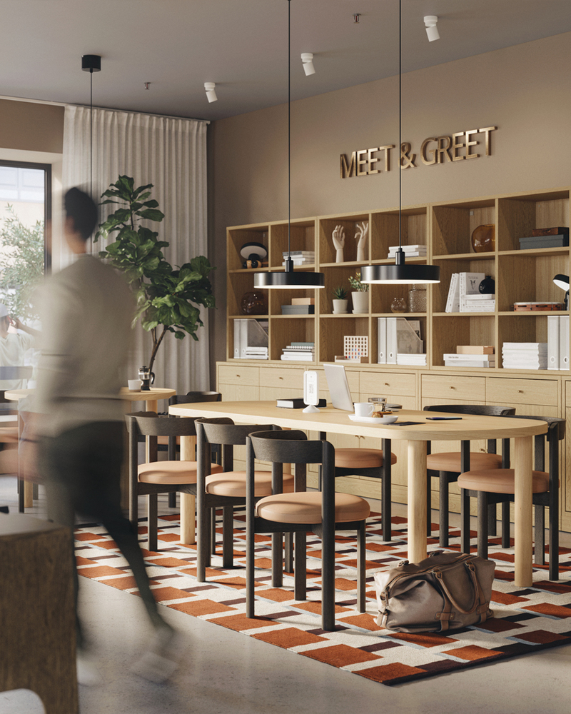 Meet-and-greet area in a hotel lobby with TONSTAD oak storage combinations, tables, chairs, and a man walking past the space.
