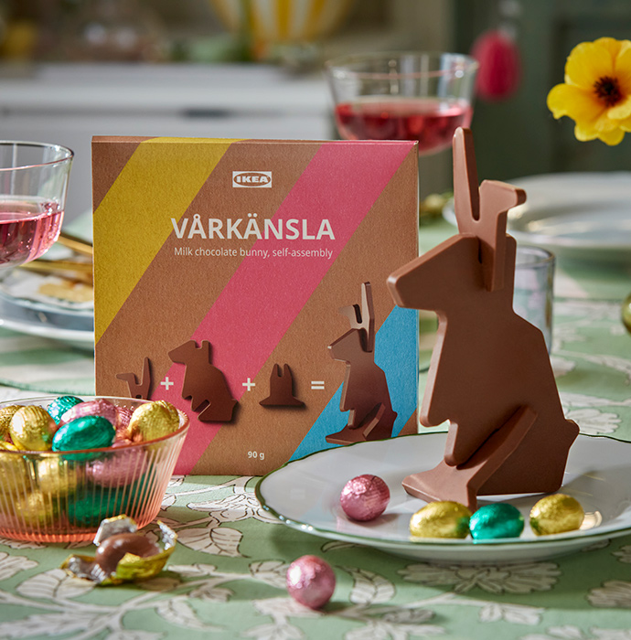 A close-up of a VÅRKÄNSLA milk chocolate bunny and some colourful VÅRKÄNSLA milk chocolate eggs nestled in a decorative bowl.
