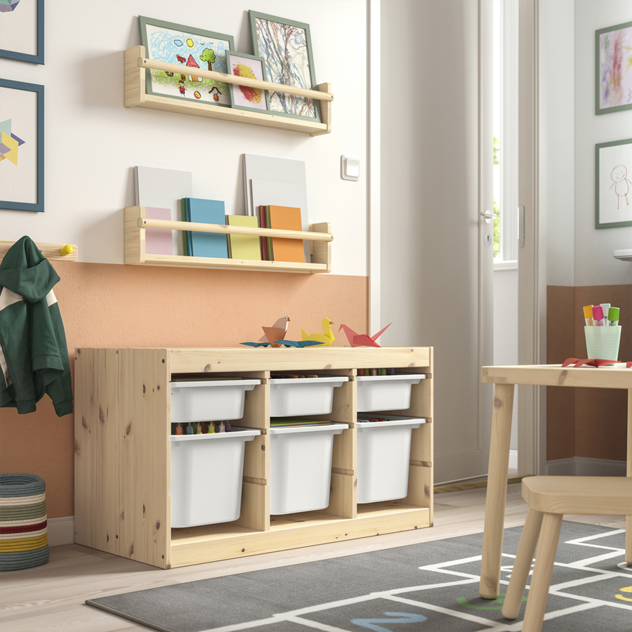 Light wood furniture, book ledges, and white bins in a children's room.