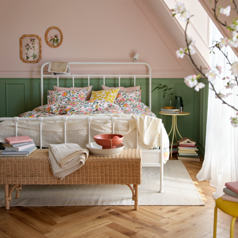 A bright bedroom featuring a white STJÄRNÖ bed frame adorned with a colourful DAGGSALVIA duvet cover and pillowcase set.