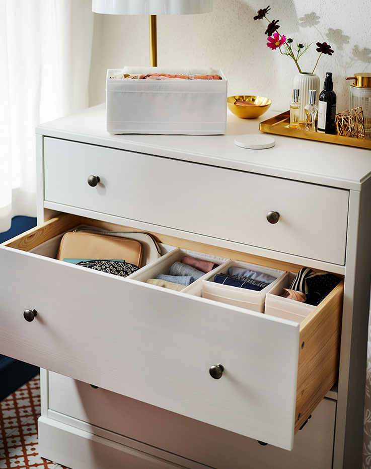 A HAVSTA chest of drawers with the middle drawer open showing folded clothes in SKUBB boxes. A white SKUBB box is on top.