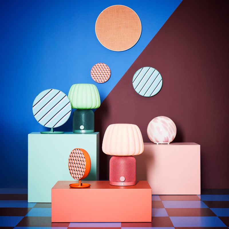 A playful pedestal arrangement of KULGLASS and SOLSKYDD Bluetooth speaker lamps and speakers, along with a FADO lamp