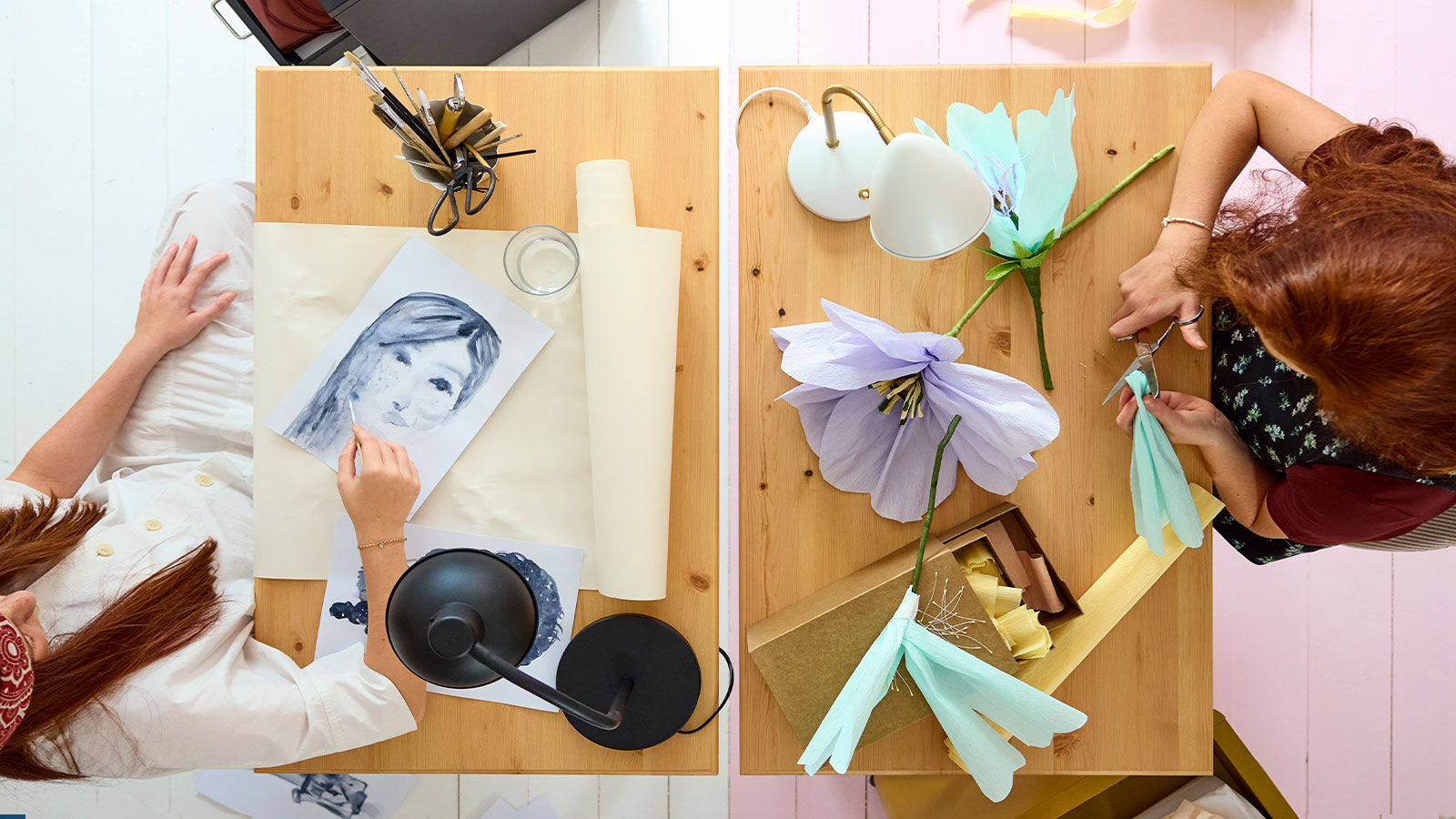 Two BOLLPOJKE desks in pine/white side by side, viewed from above, with two teens crafting and using art supplies.