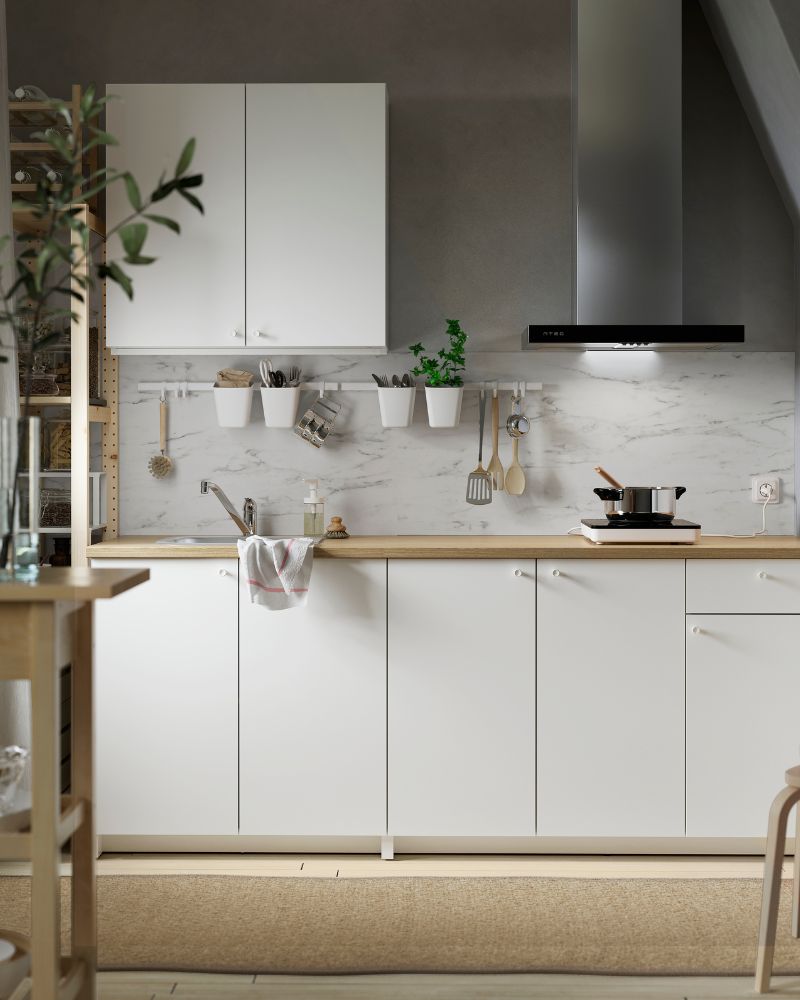 Modern kitchen with white SEKTION and KNOXHULT cabinets, IVAR shelving, and a beige MORUM rug.