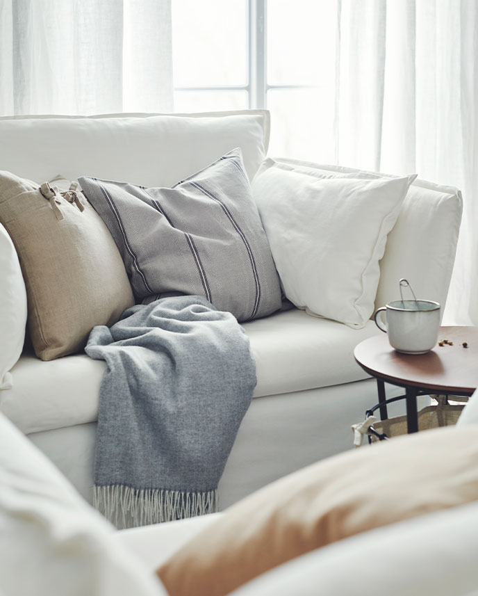 On a LOHALS rug are two FRÖSET chairs with MAJSMOTT cushions. In the background are dark-gray PAX wardrobes.