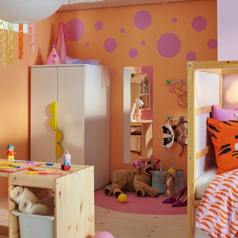A light white stained pine TROFAST frame and tabletop make a desk in a child’s bedroom with a SMÅSTAD/PLATSA wardrobe