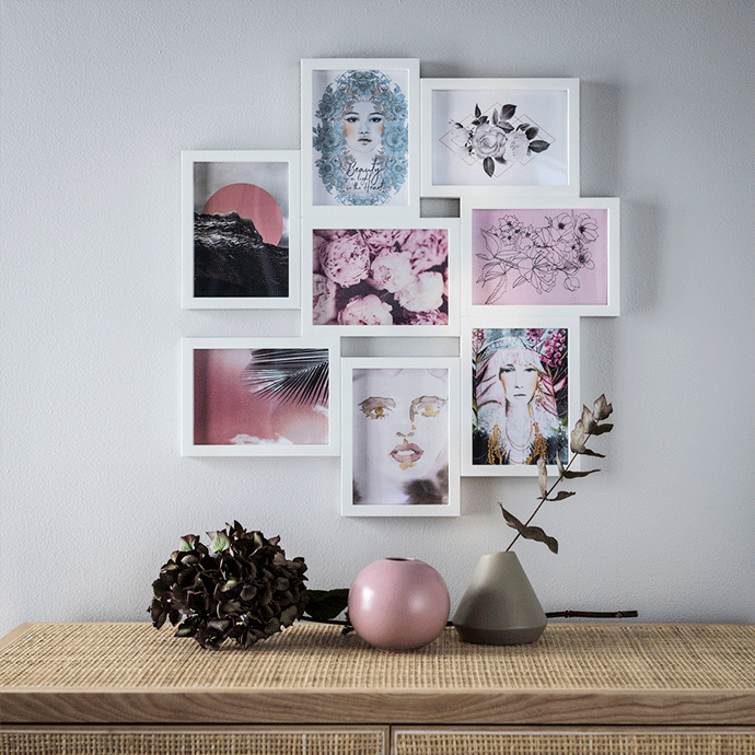 Collage of eight interconnected white frames on a grey wall featuring floral and portrait art in pink and blue tones, positioned above a rattan sideboard with decorative vases.